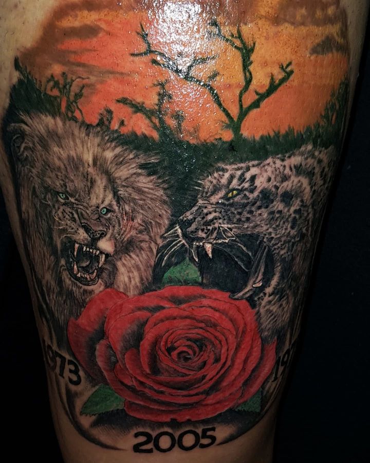 Tatuaje a color de un león, un leopardo y una rosa roja